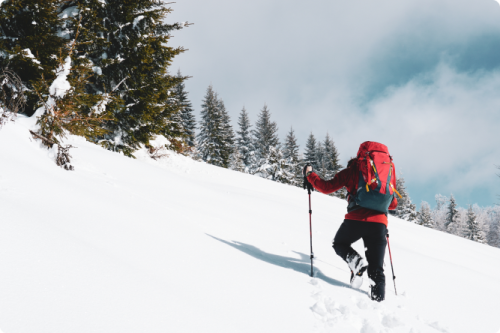 beautiful-shot-male-hiker-with-red-travel-backpack-hiking-up-snowy-mountain-winter (1)